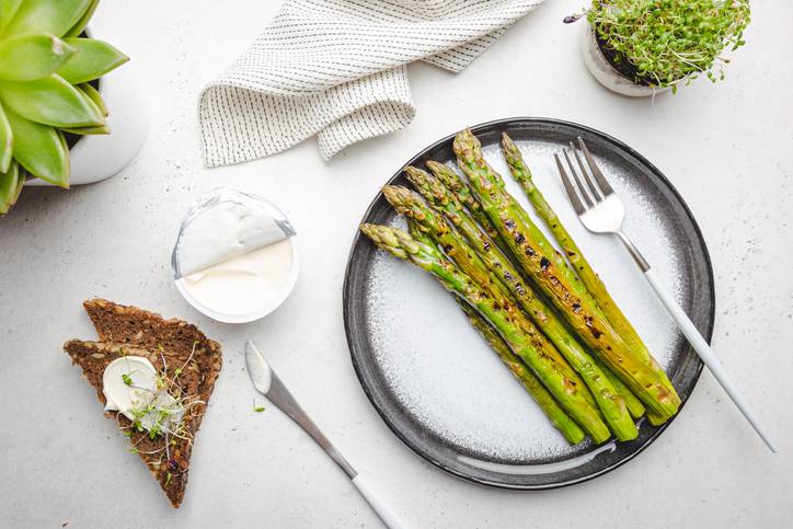 A white plate filled with cooked asparagus