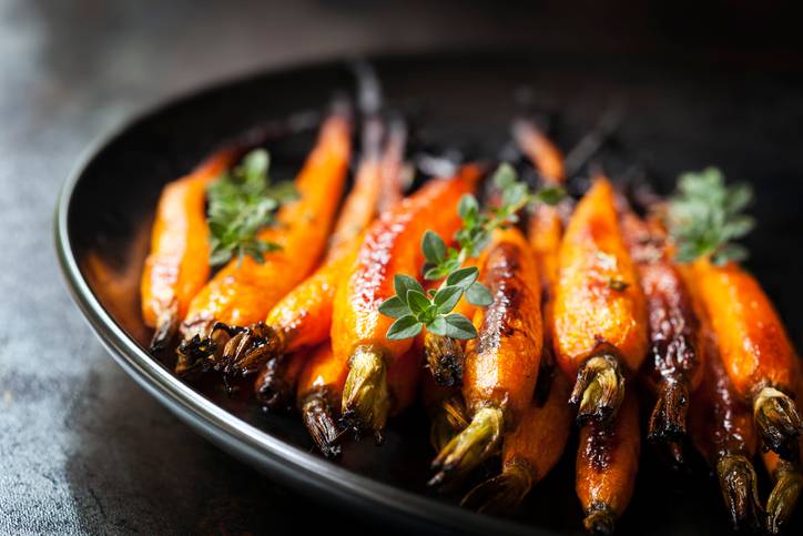 cooked carrots in a black pan with herbs