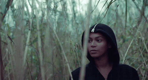 Beyonce in tall grass reeds in the video for all Night