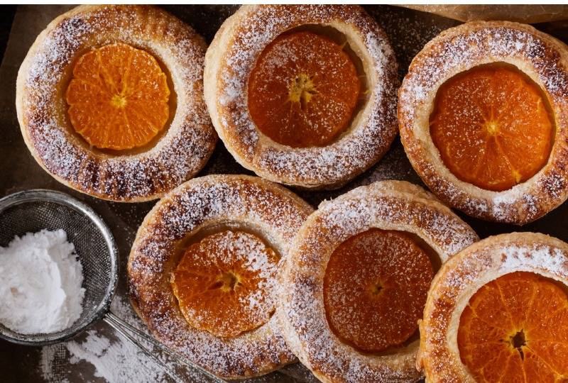 Orange puff pastries sprinkled with icing sugar