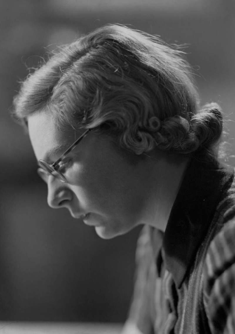 Black and white photo of Elizabeth Maconchy's side profile with her hair up and wearing glasses