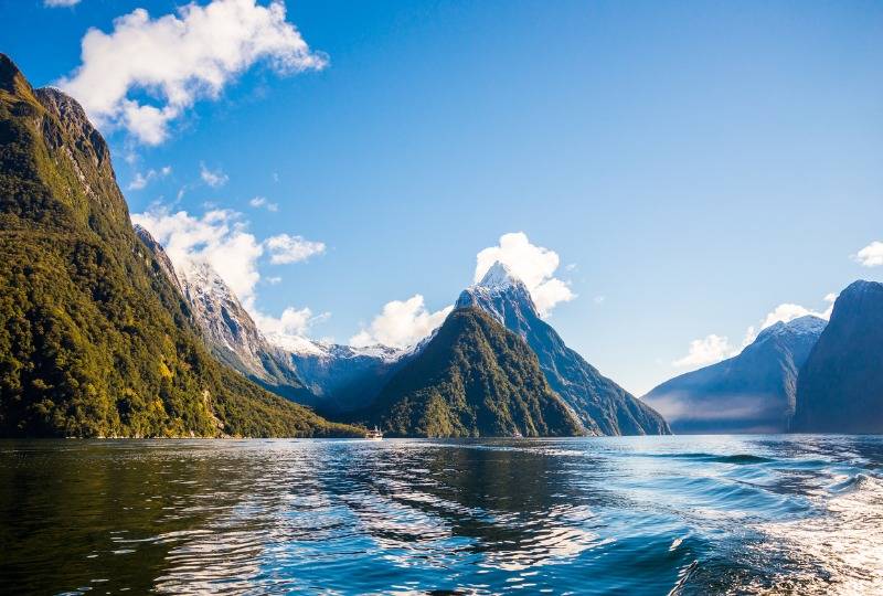 Mountains fringing lake at Milford Sound in New Zealand