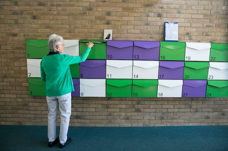 New Ground resident checks her purple, green and white mailbox