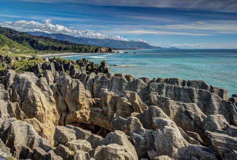  Pancake rocks at Punakaiki in New Zealand with clear blue sea and sky in background