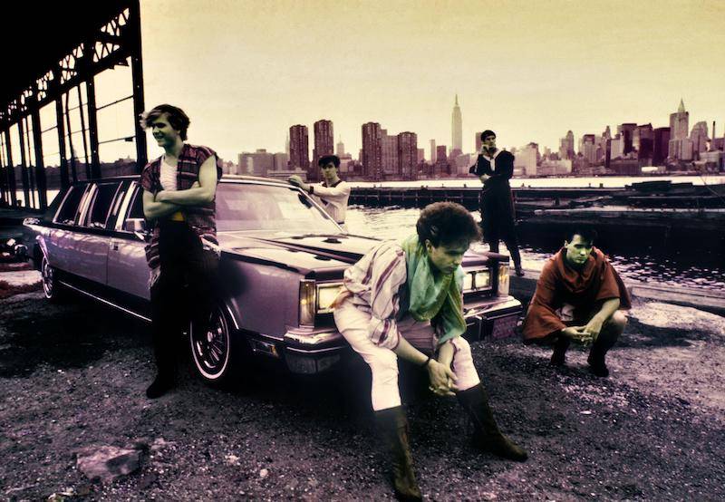 Spandau Ballet band members lean against a car on the shore in New York