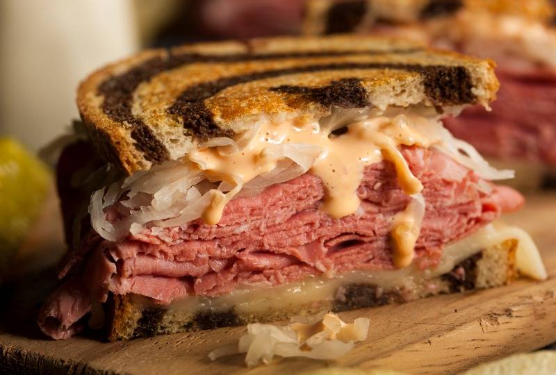 The Reuben sandwich made with toasted bread, Swiss cheese and pastrami 