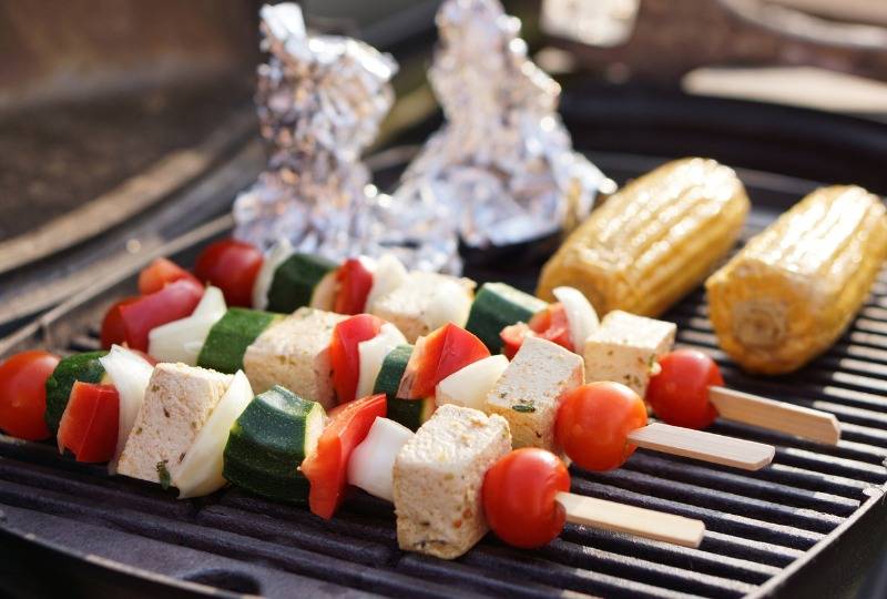Tofu skewers served with tomatoes and cucumber on barbecue