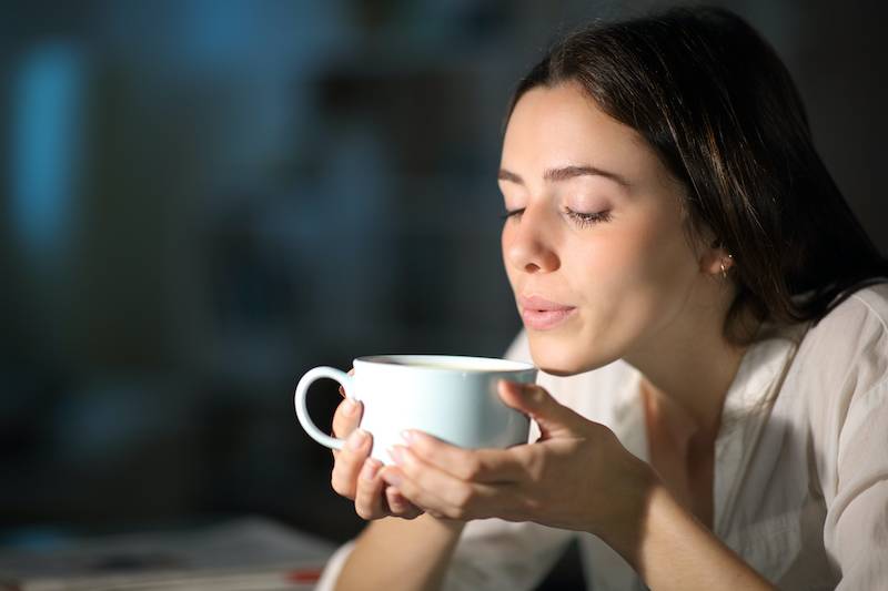 Woman drinking tea at night