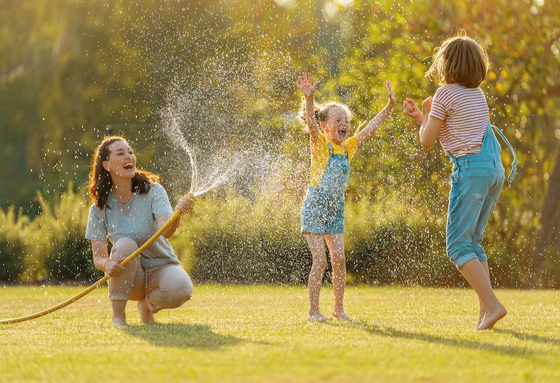 Family playing with sprinklers