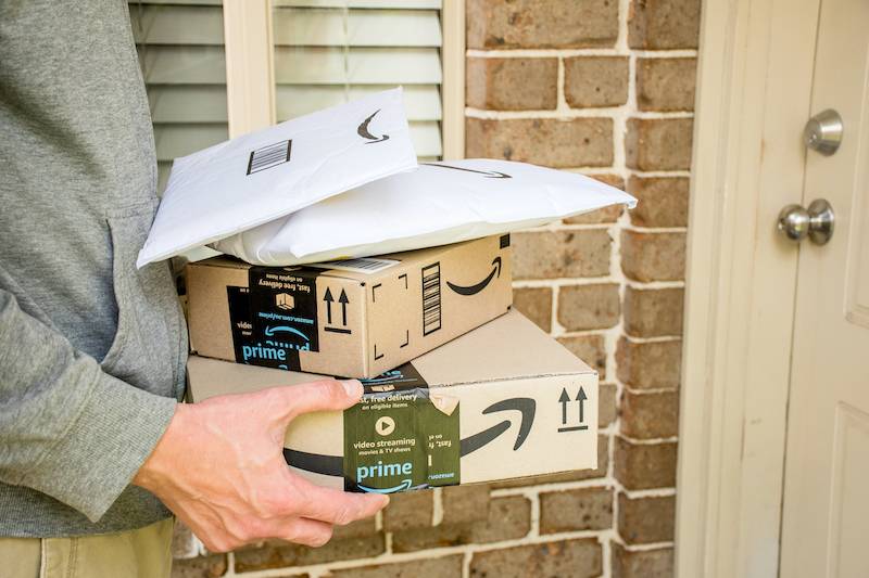 Courier holding Amazon Prime delivery parcels
