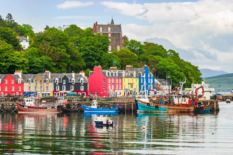 View of Tobermory bay on Isle of Mull with famous colourful houses and trees behind