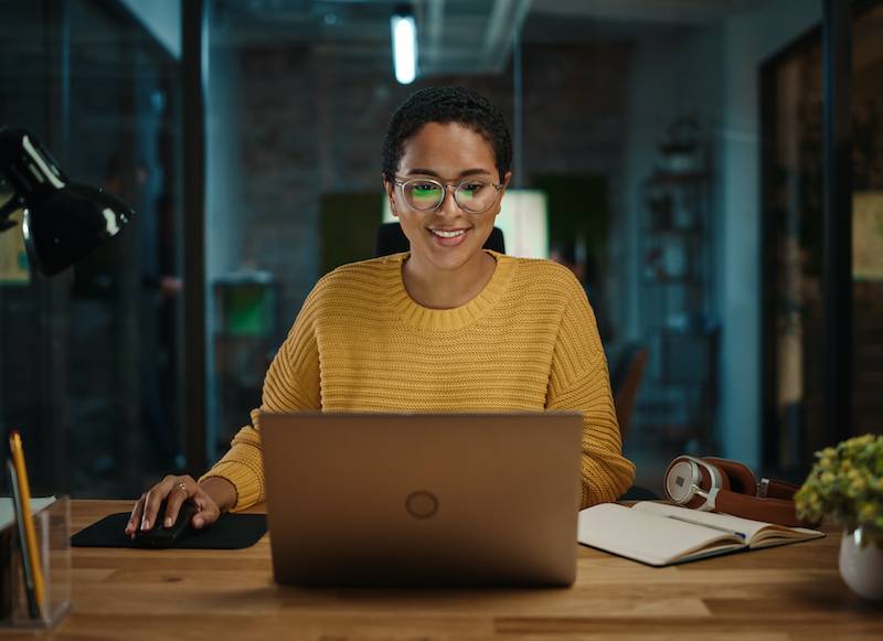 Black woman at laptop smiling