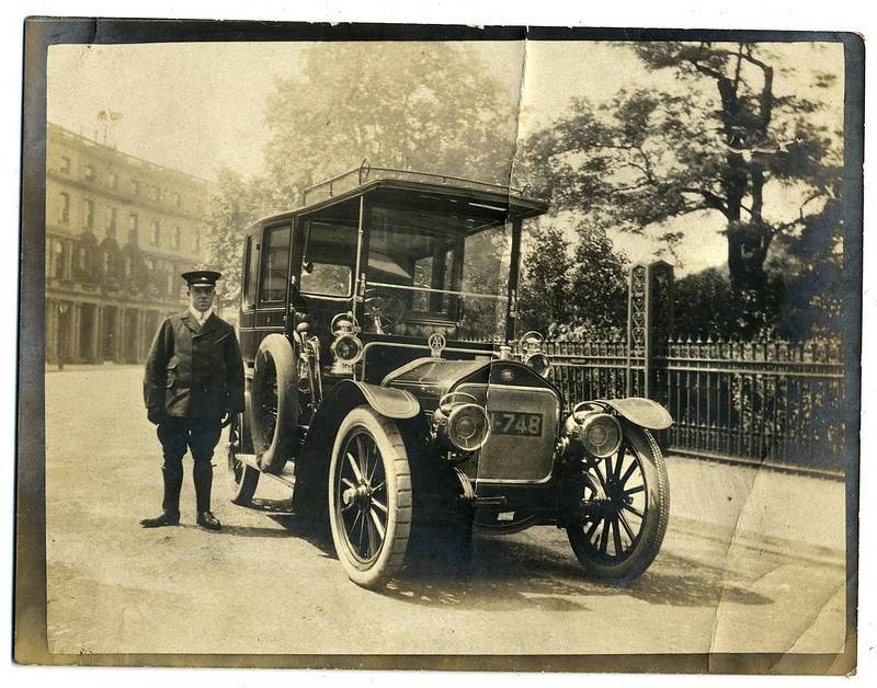 Chauffeur stood next to automobile in London
