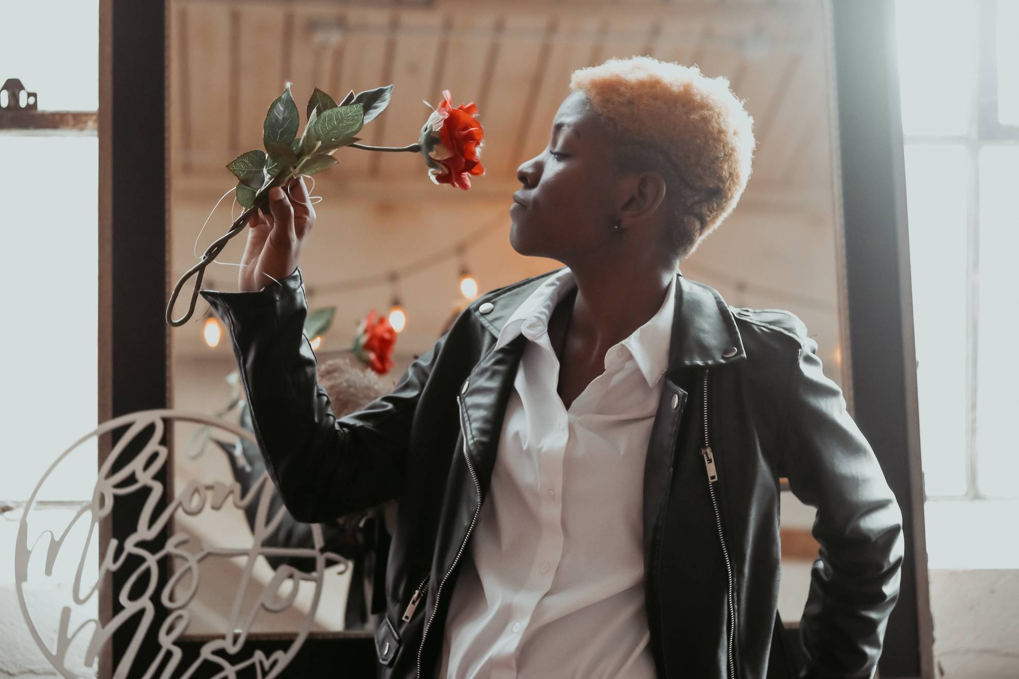 androgynous model smells a rose