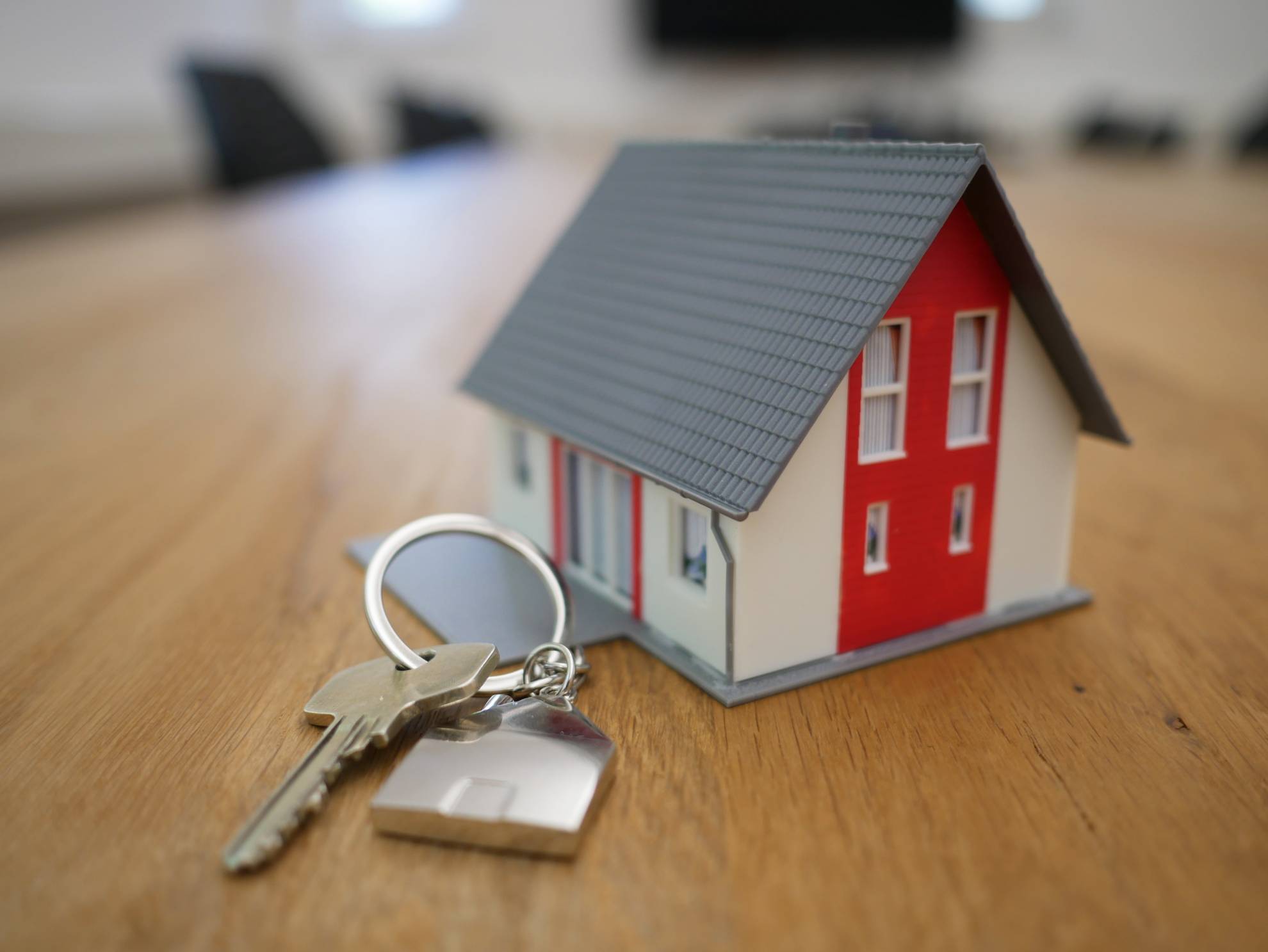 a model house sits next to a pair of keys