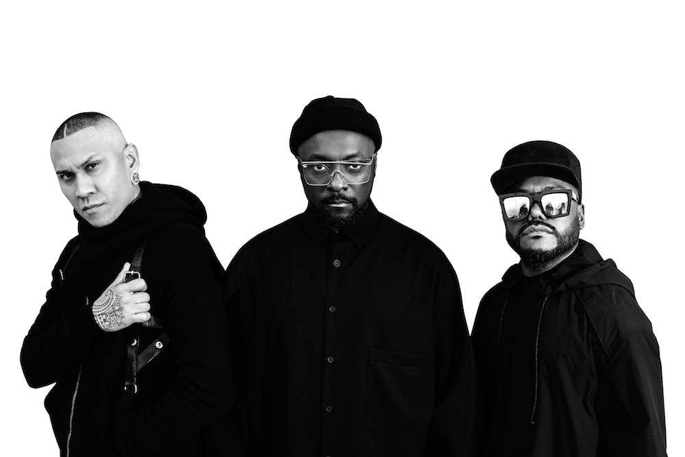 the black eyed peas stand facing camera in black and white photograph