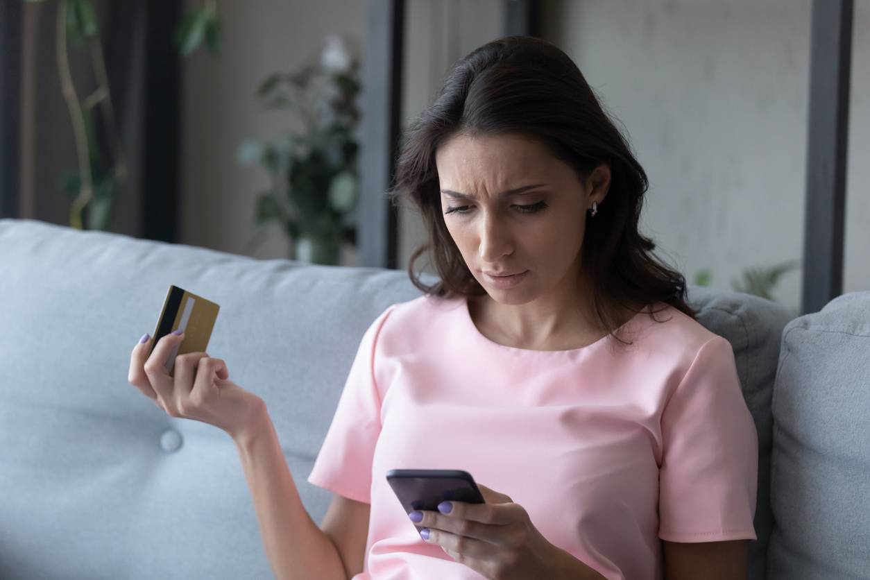 woman staring at credit card in despair