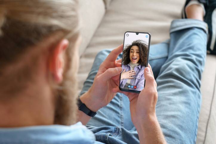 young man holds his phone to zoom with a girl