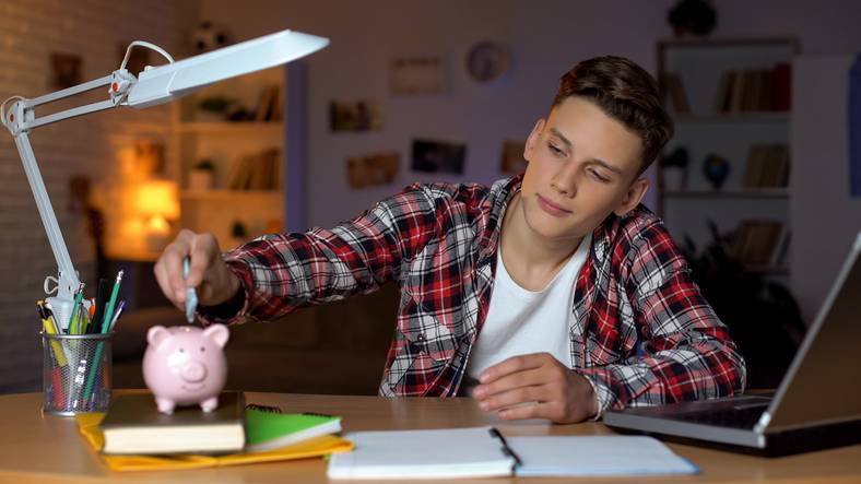 teenage boy using his piggy bank