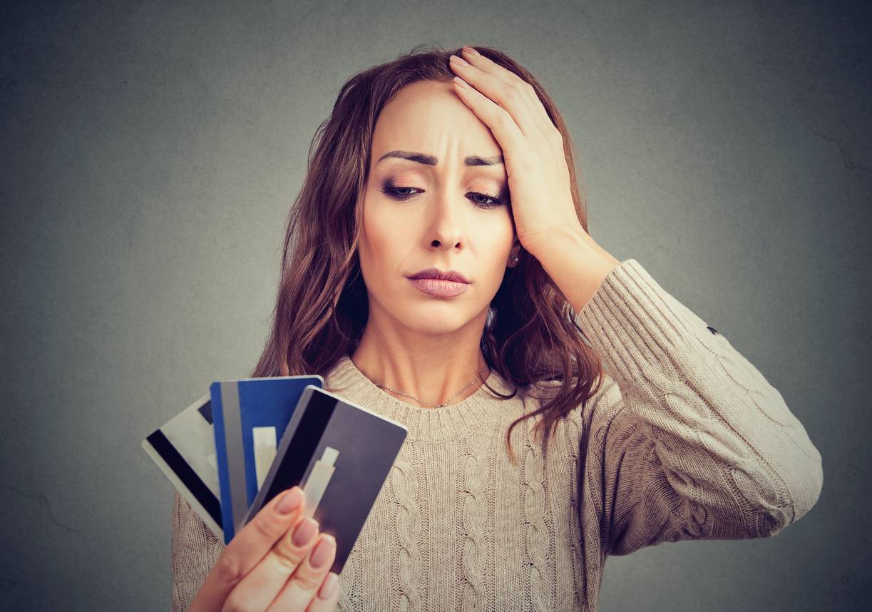 Stressed woman holding credit cards
