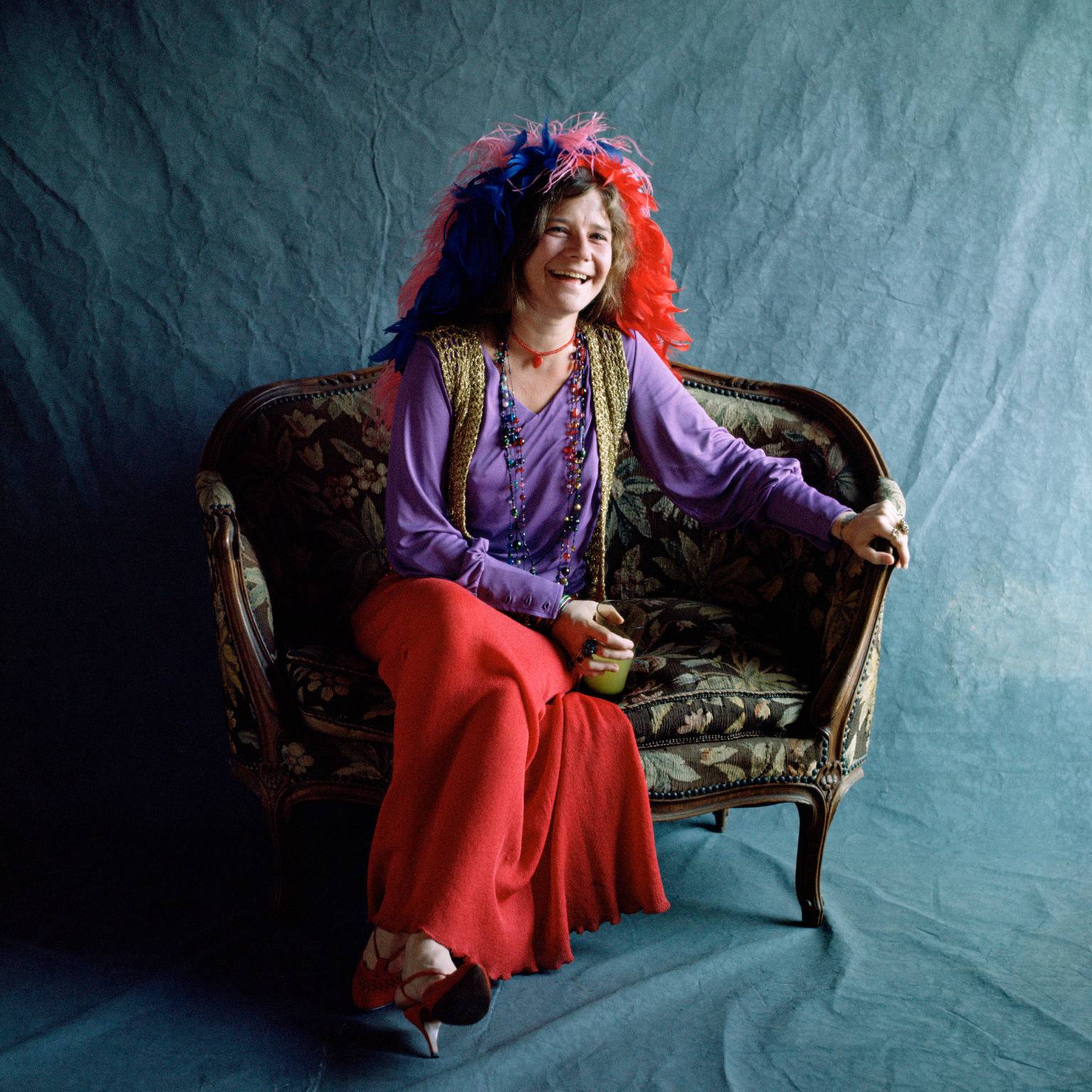Janis Joplin sat on a chair laughing