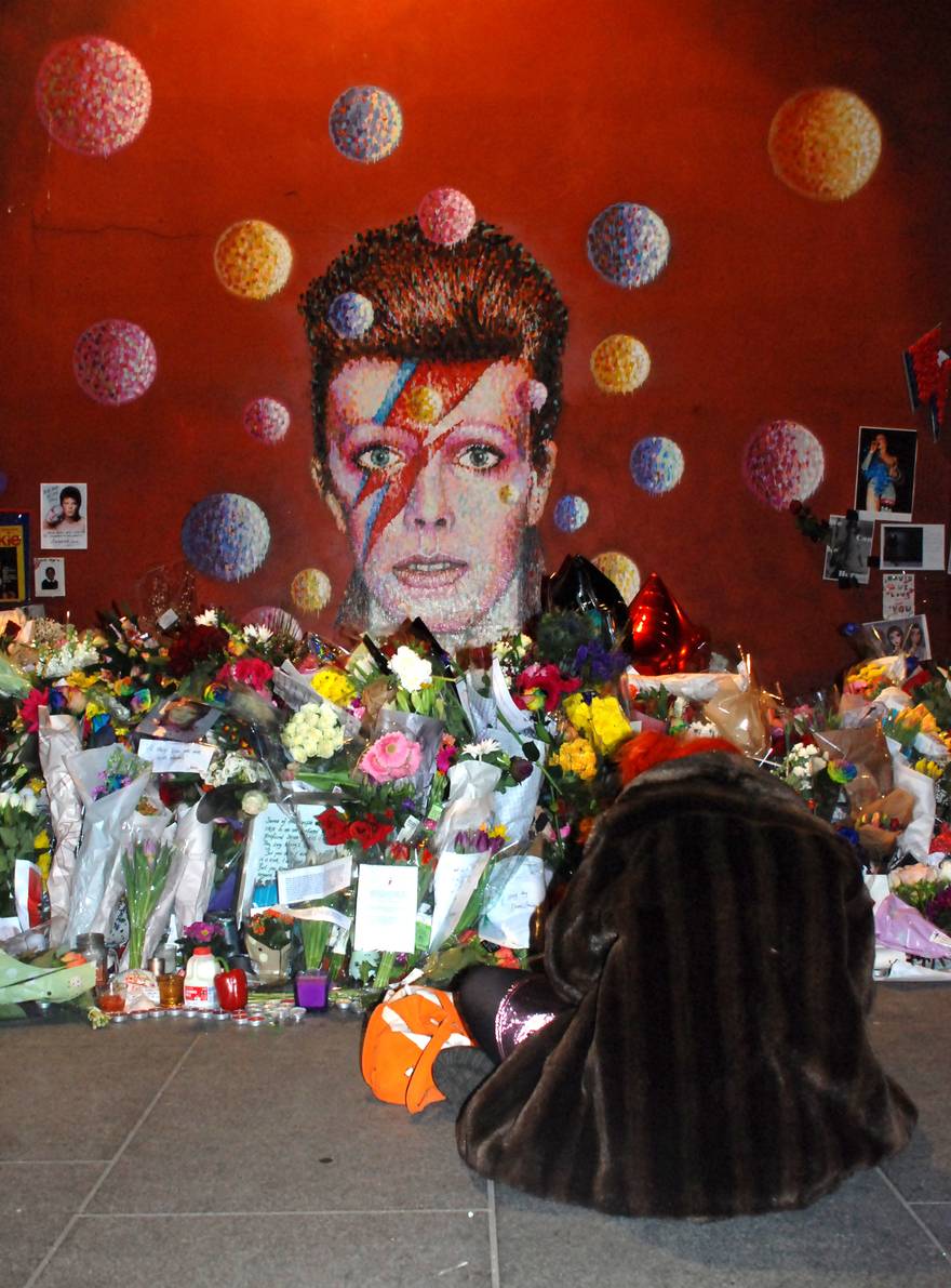 A fan mourns at a David Bowie mural
