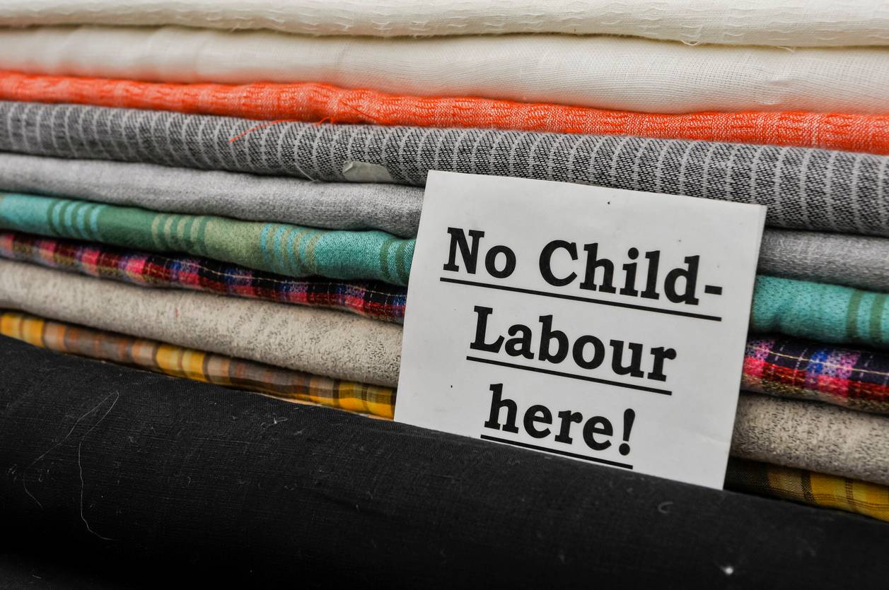 Sign on a pile of clothes saying 'no child labour'