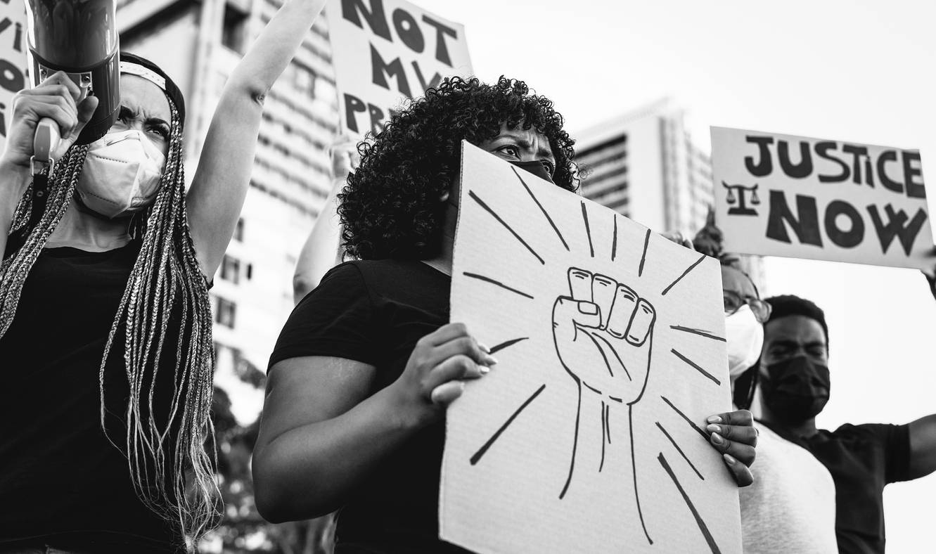 A Black woman holding a Black Power sign at a protest