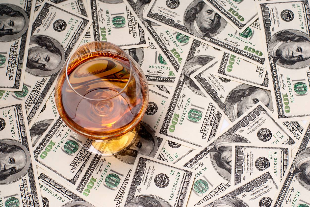 Whisky with dollar bills underneath
