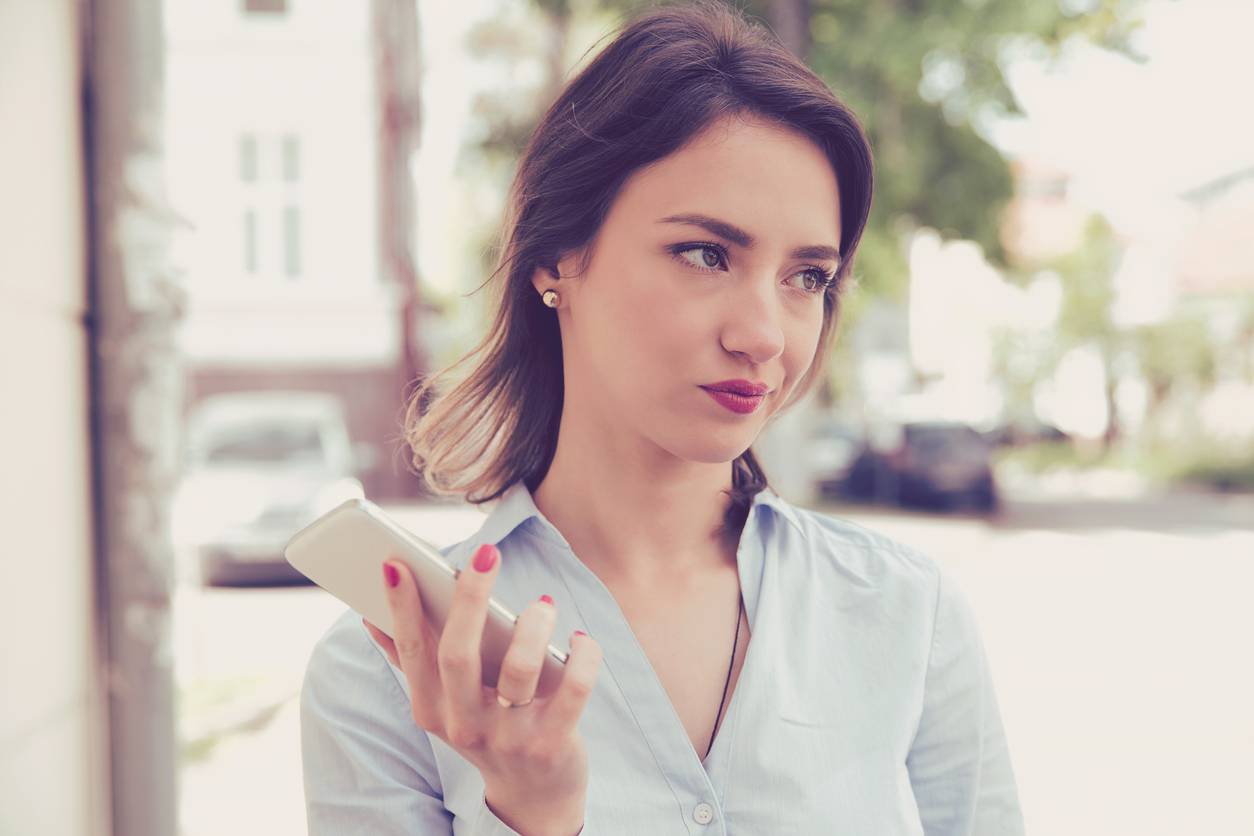 A sad and frustrated looking woman holding a phone