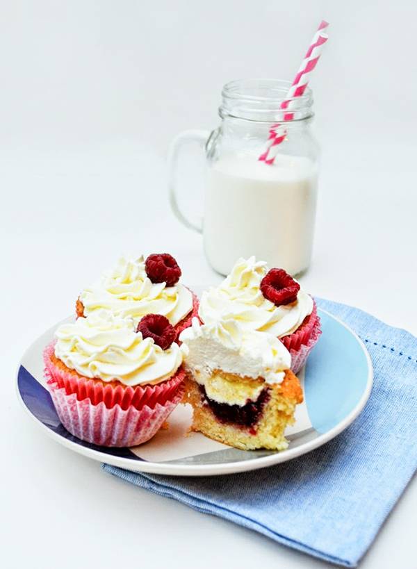 Vanilla cupcakes with clotted cream and fresh raspberries